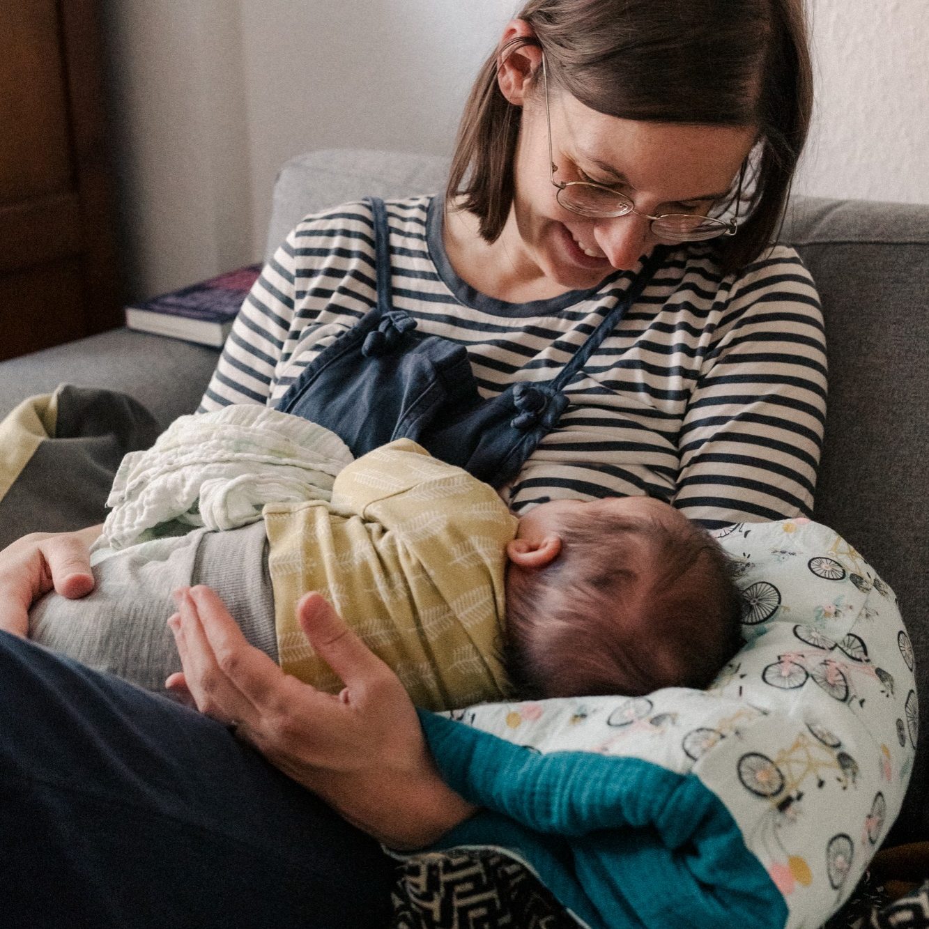 Stillende Mutter mit Kobelwerk Haltekissen, einem kleinen Stillkissen über dem Arm
